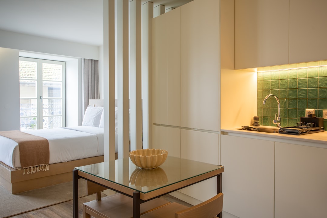 a-room-with-a-bed-and-a-table-with-a-bowl-on-it-deuvqnbwruw