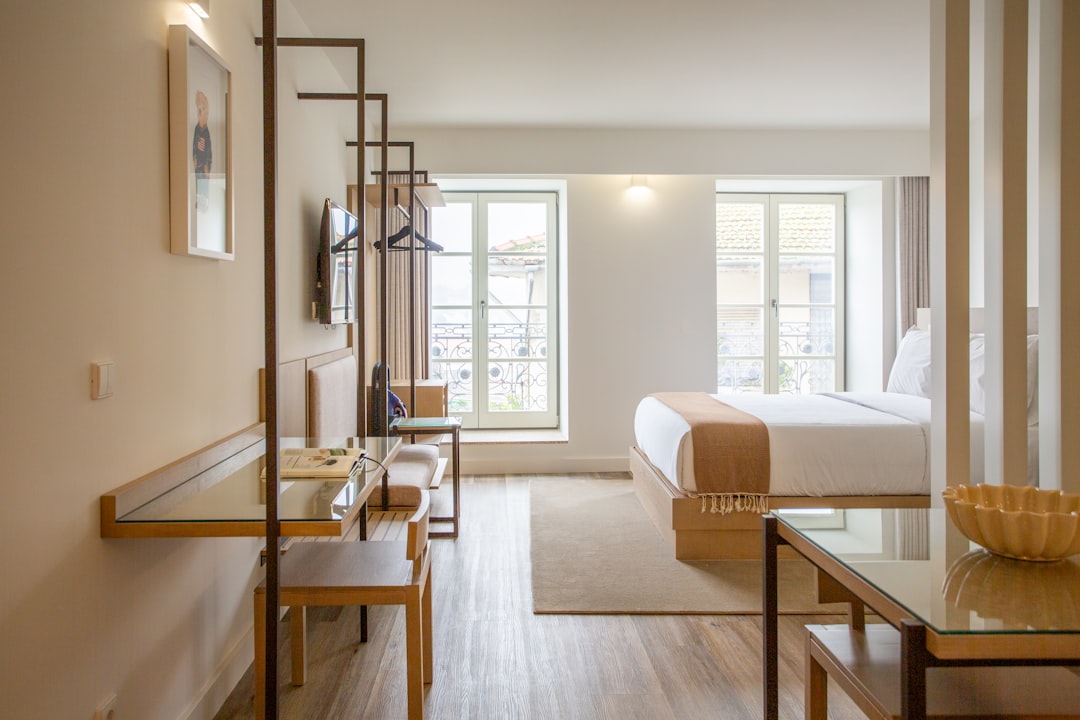 a-hotel-room-with-a-bed-desk-chairs-and-a-television-1ejxslufqu0